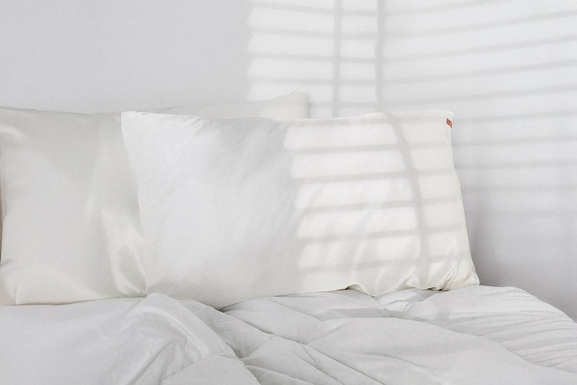 White pillows on a bed with a neutral background