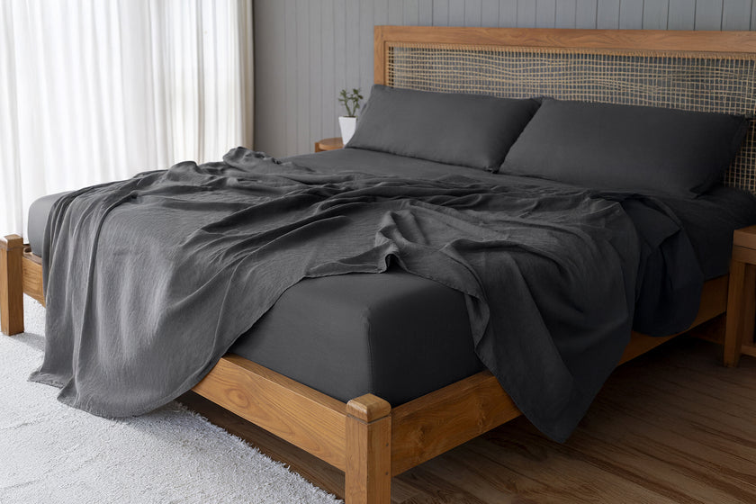 Linen charcoal sheets on a wooden bed