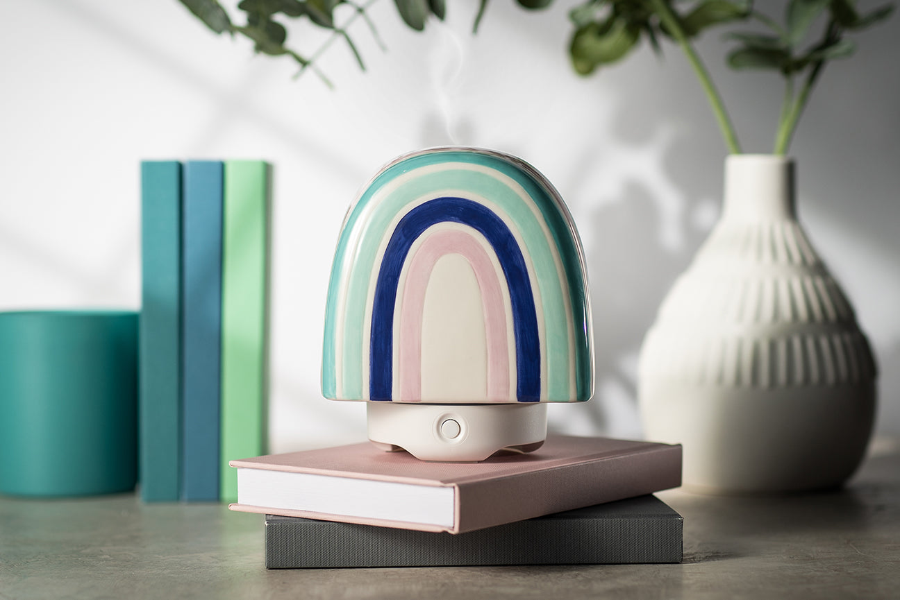 The woolzies rainbow glass diffuser sitting atop two stacked books