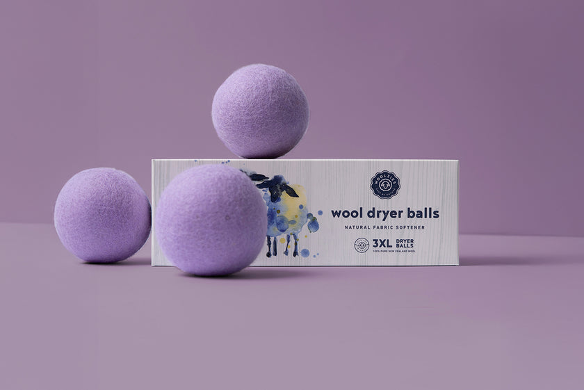 lavender wool dryer balls on top of their packaging box