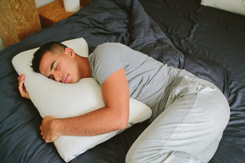 A man sleeping on his side resting his head on a side sleeper easy breather natural pillow